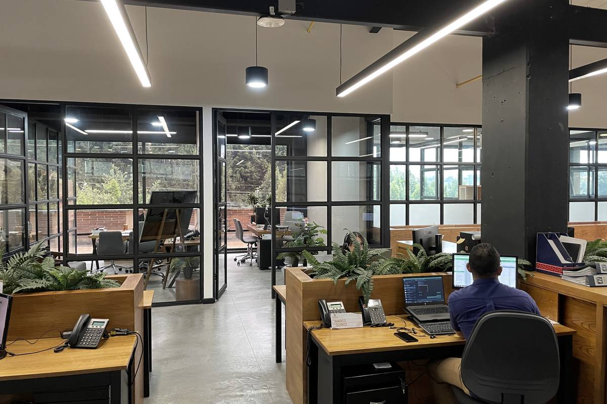 A glass-walled meeting room off the main floor, looking out onto the courtyard.